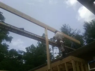 Carpenter setting a ridge beam over a new addition frame — Ice Dam Removal by Roofing Brothers in Mount Vernon